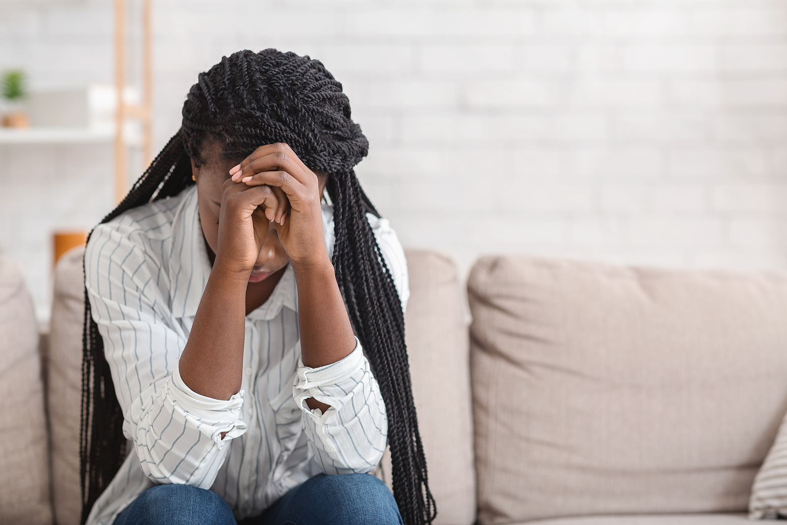 Photo of a person resting their head on hands representing a person who is expressing anger but recognizes it is a secondary emotion and is acknowledging the despair underneath.