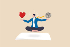 Image of a man in a suit levitating with a heart over the right hand and ball of tangled lines in the other. Representing someone who is learning to balance their emotions through anger management therapy in Philadelphia, PA.